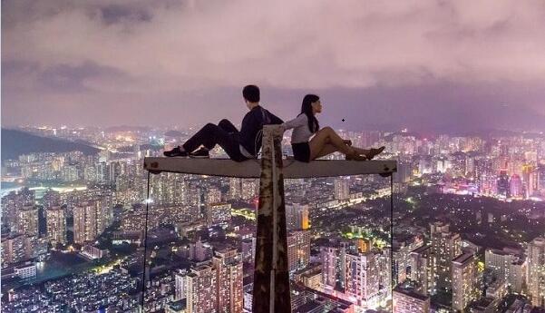 Man and woman sitting on top of building